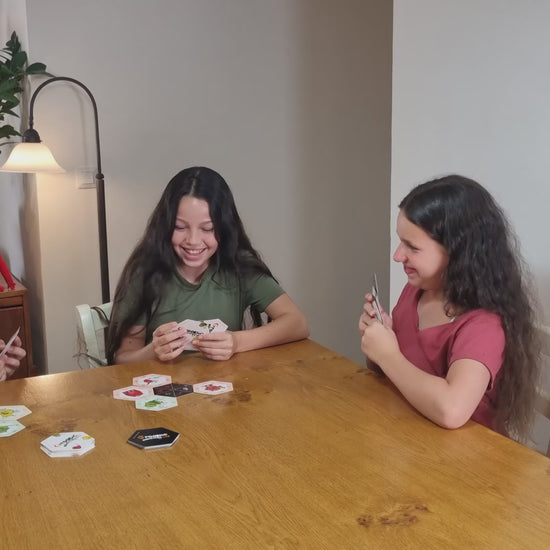 Kids playing Groopic.
Groopic Monster's Style is an ingenious twist on the classic rummy game mechanic. It combines a card grouping strategy with a wonderfully whimsical monster theme.
Instead of sets and runs, players collect groups of hexagonal Monster Cards around central Groopic Cards depicting monster activity symbols. Rearrange groups strategically to be the first to get rid of all your cards!
